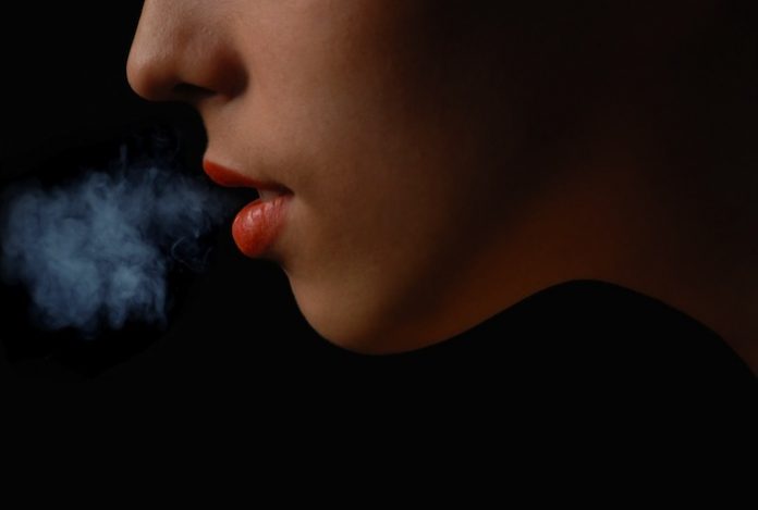 woman blowing smoke