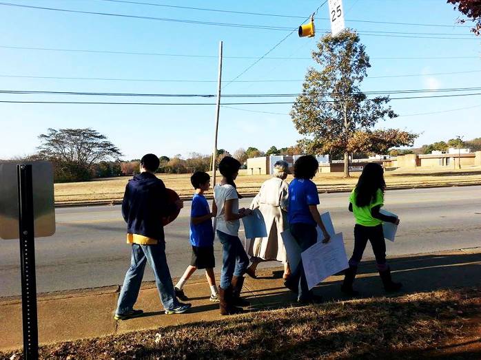 Forced-birth commandos lead children in a protest across the street from a school